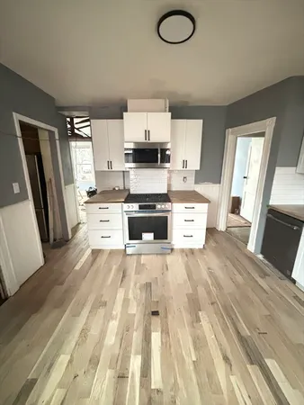 a large white kitchen with wooden floors