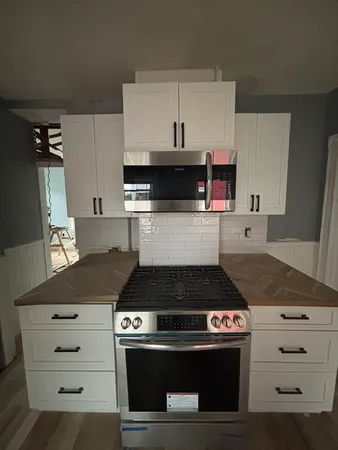 a kitchen with a stove and white cabinets