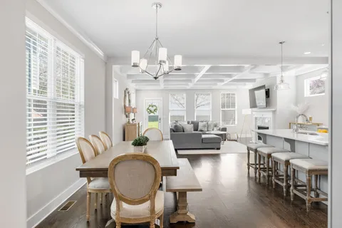 a living room with furniture chandelier and a large window