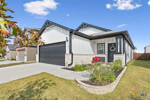 a view of a house with a small yard and potted plants