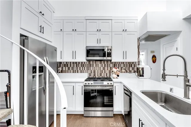 a kitchen with white cabinets and appliances