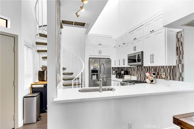 a kitchen with stainless steel appliances a sink and a refrigerator