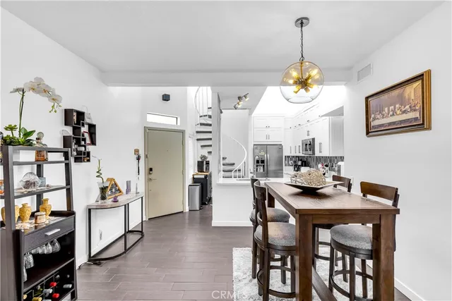a view of a dining room and kitchen with a table chairs and chandelier