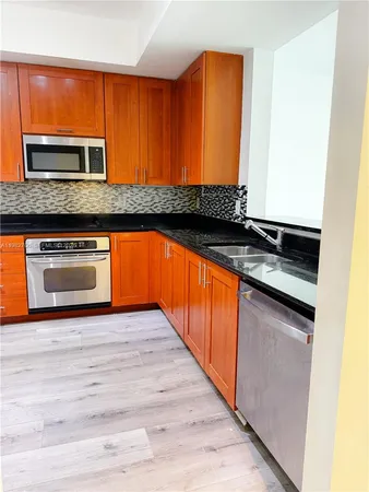 an empty room with wooden floor and cabinet