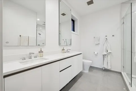 a spacious bathroom with a double vanity sink mirror and toilet