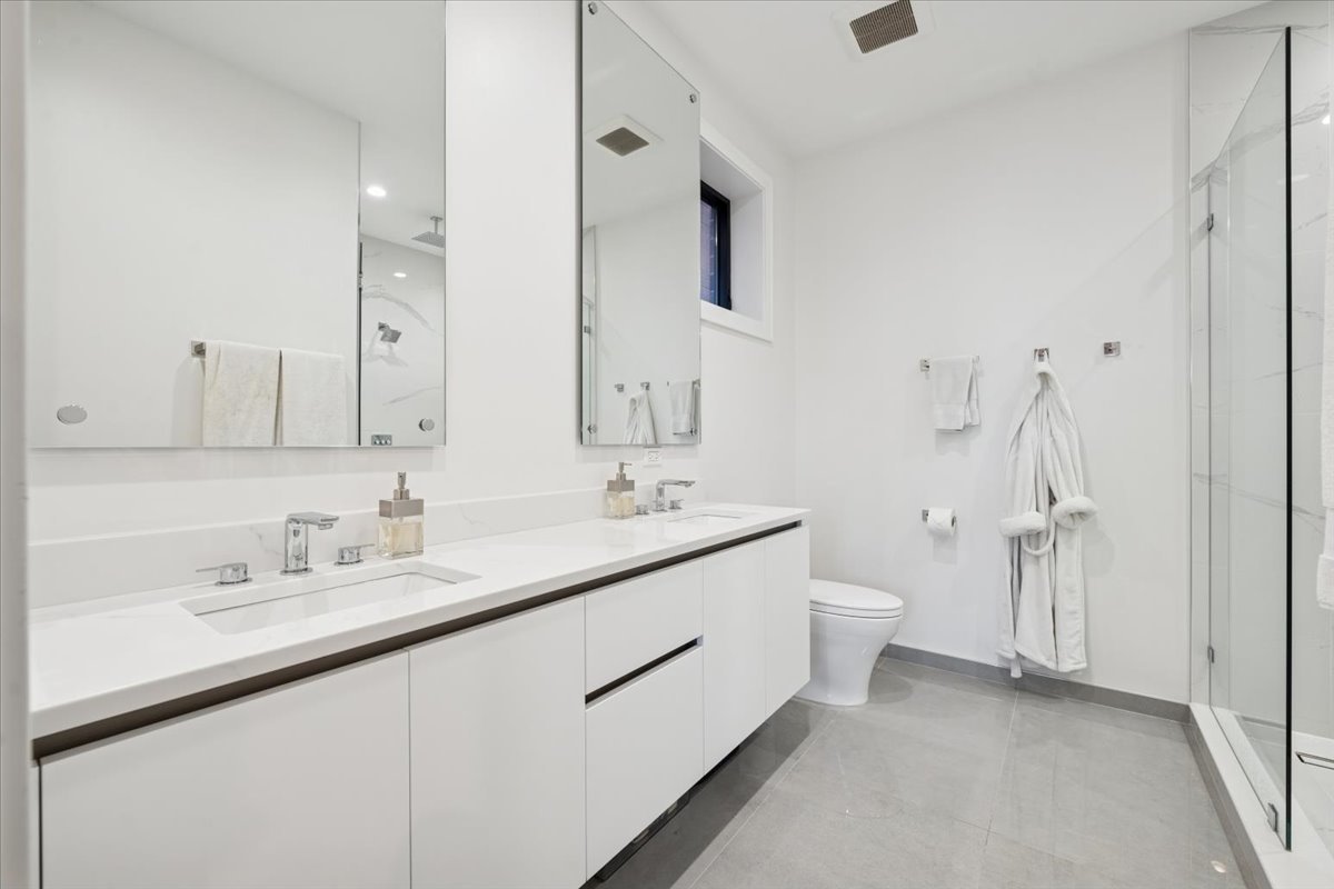 2228 West Belmont Avenue, Unit 2 Chicago, IL 60618 - Photo 12 of 18 a spacious bathroom with a double vanity sink mirror and toilet