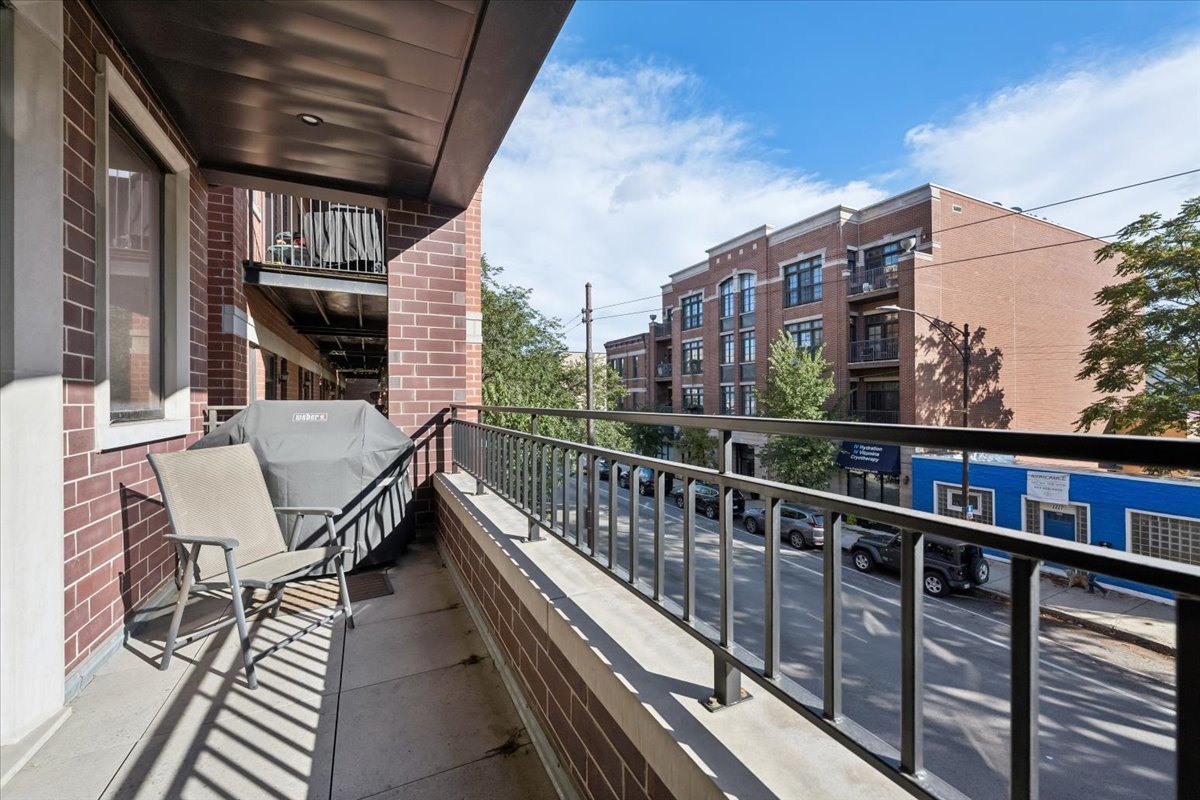 2228 West Belmont Avenue, Unit 2 Chicago, IL 60618 - Photo 18 of 18 a view of a balcony with a large window and wooden floor