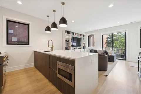 a kitchen with a sink and a stove top oven with wooden floor