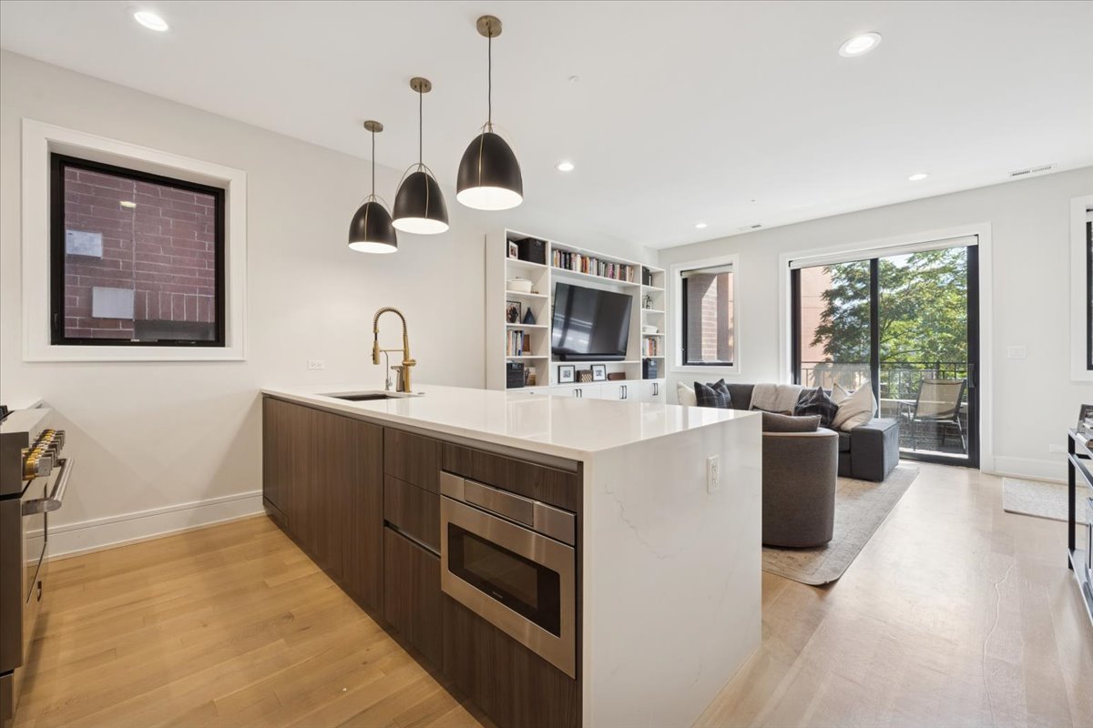 2228 West Belmont Avenue, Unit 2 Chicago, IL 60618 - Photo 5 of 18 a kitchen with a sink and a stove top oven with wooden floor