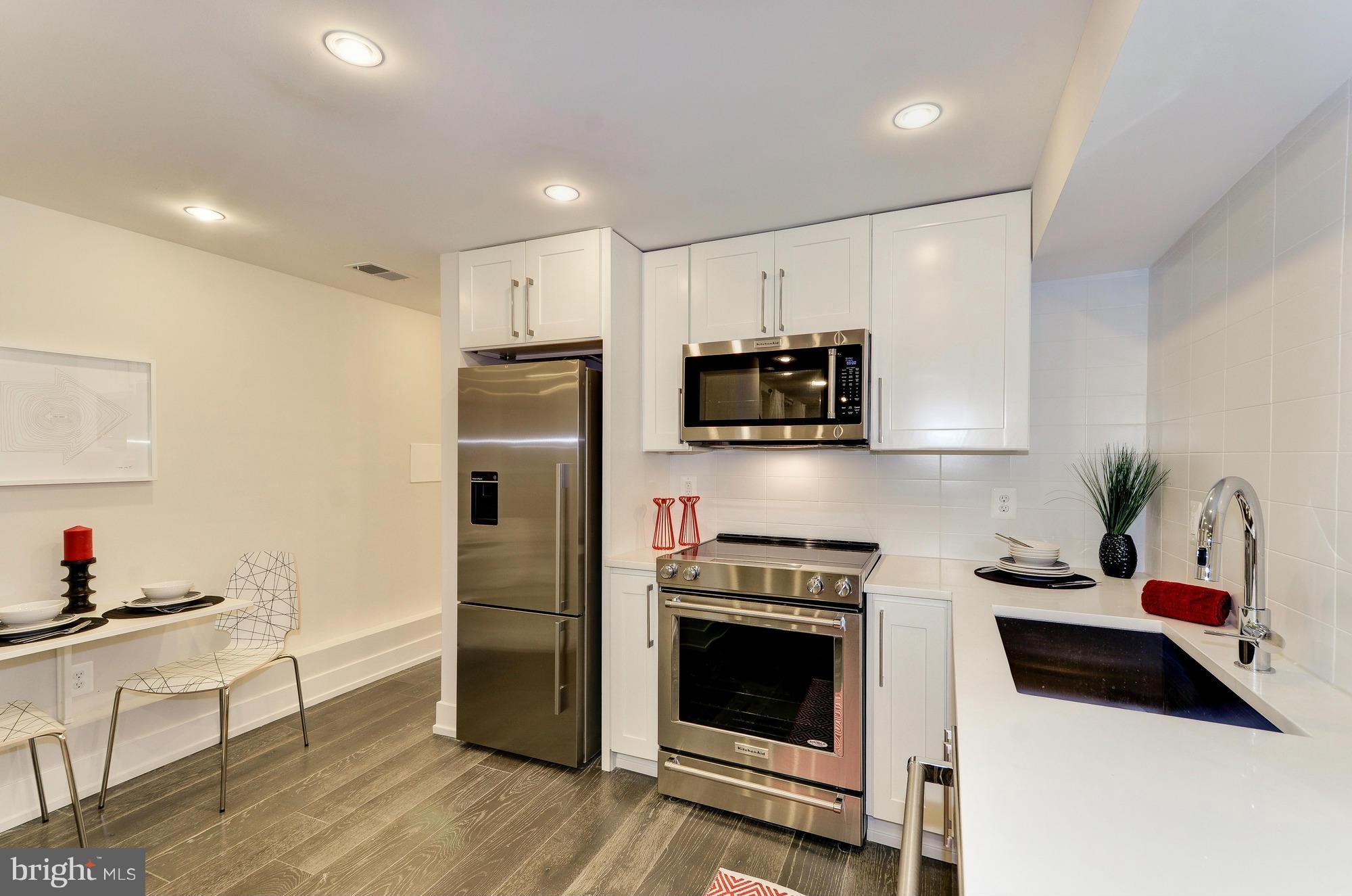 2515 17th Street Northwest, Unit 1 Washington, DC 20009 - Photo 9 of 12 a kitchen with stainless steel appliances a stove a sink a refrigerator and cabinets