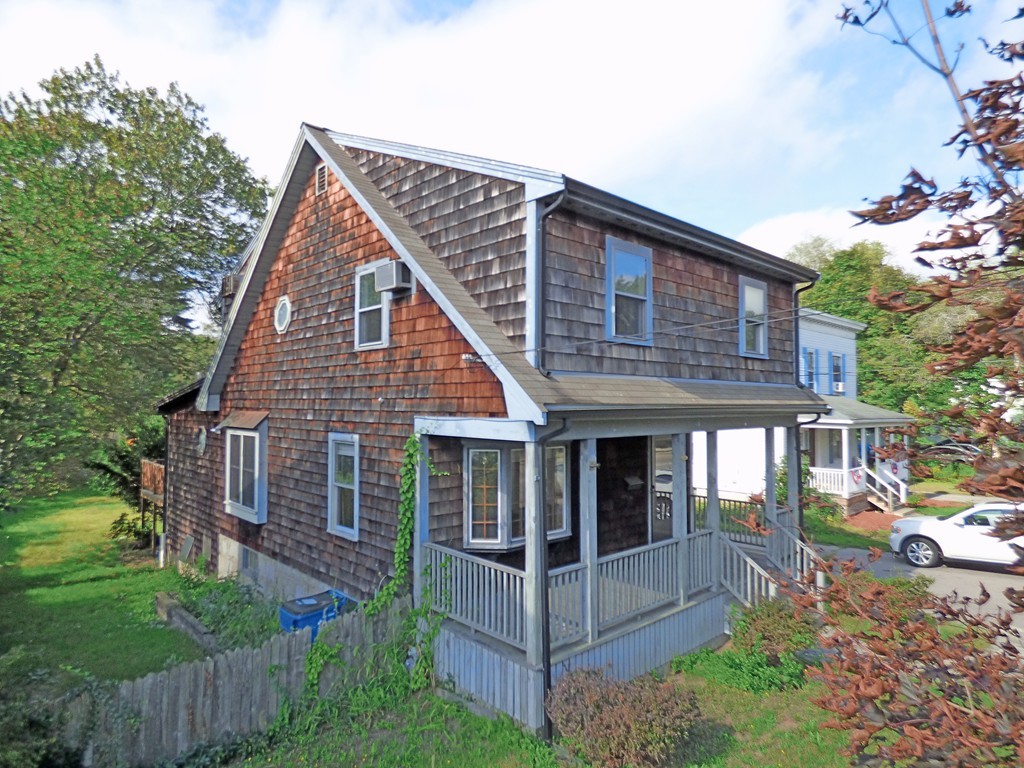 a view of a house with a yard and potted plants