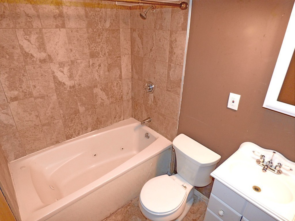 327 Union Street Randolph, MA 02368 - Photo 25 of 29 a white toilet sitting next to a bath tub