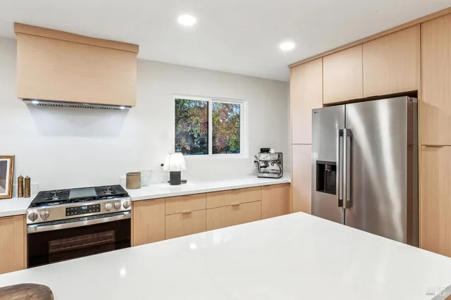 a kitchen with stainless steel appliances a refrigerator sink and stove