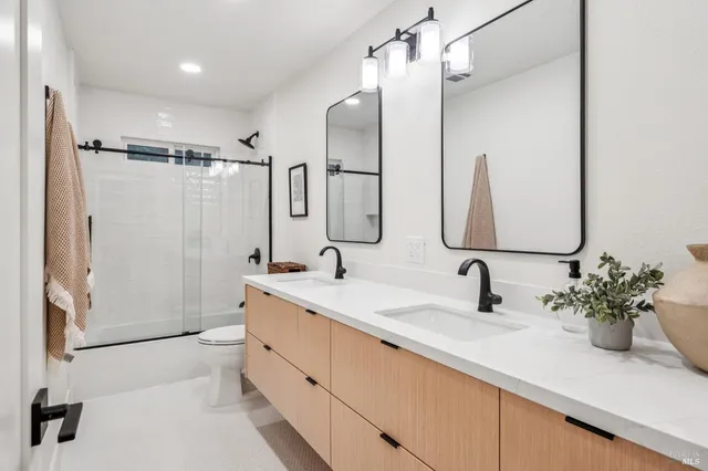 a bathroom with a double vanity sink mirror double and shower