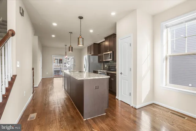 an empty room with chandelier fan and windows