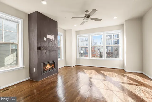 a view of an empty room with a window and a kitchen
