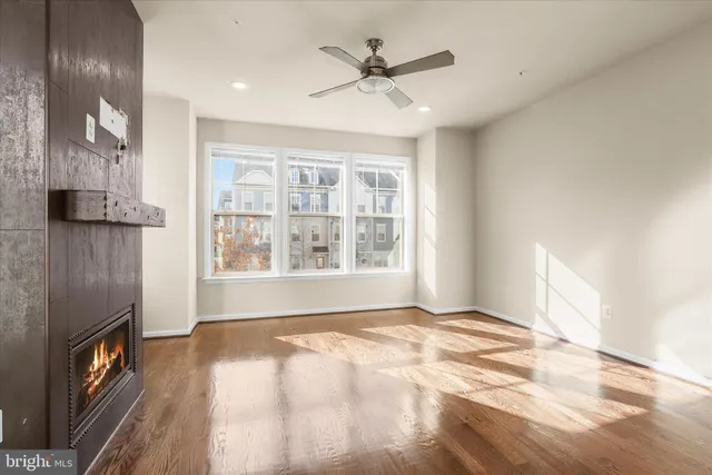 a view of a living room and kitchen with furniture wooden floor and a large window