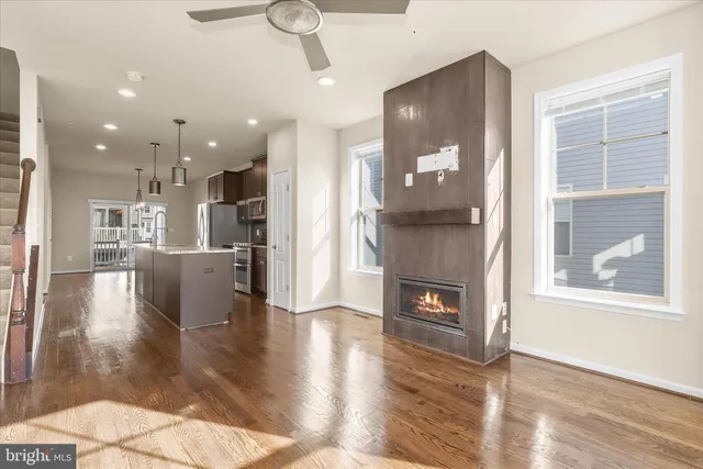 a kitchen with stainless steel appliances granite countertop a refrigerator a oven a sink with island and wooden floors