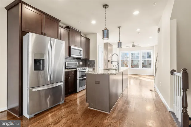 a kitchen with stainless steel appliances granite countertop a sink refrigerator and microwave