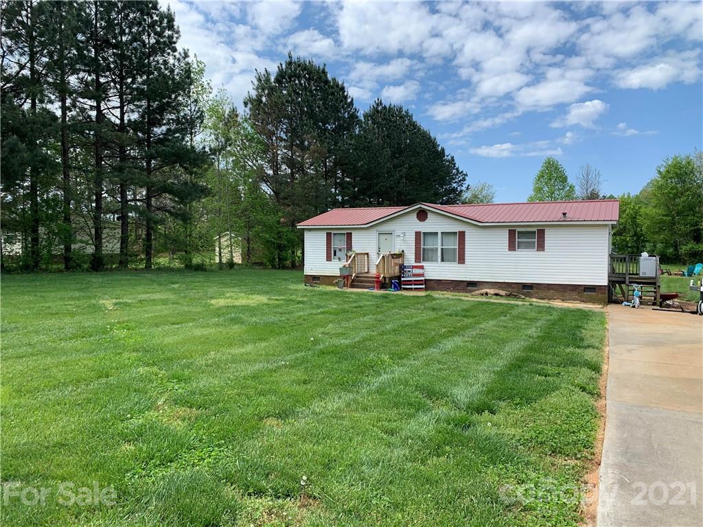 2208 Chenault Road, Unit L5 Cleveland, NC 27013 - Photo 1 of 9 a white house with a big yard plants and large trees