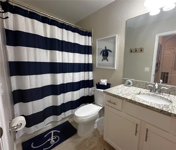 a bathroom with a sink a toilet a shower and a mirror