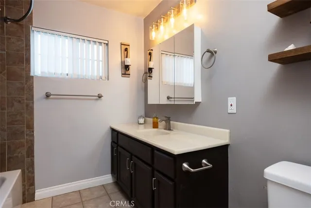 a bathroom with a sink a toilet and a mirror