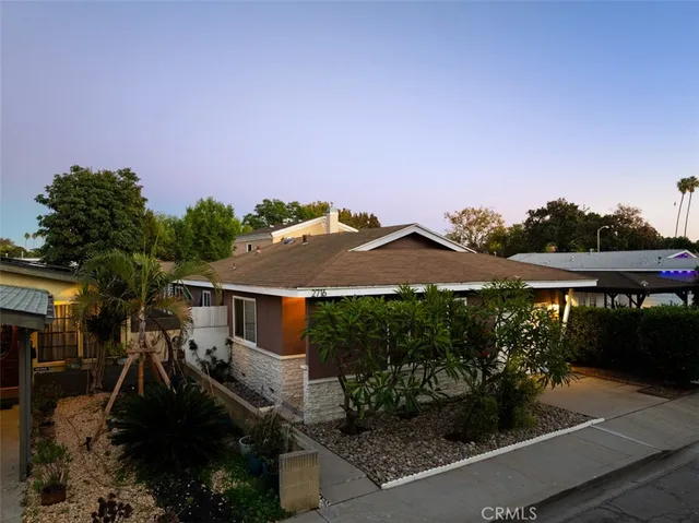 a view of a house with a yard and potted plants