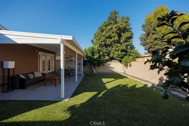 a view of a house with backyard and sitting area