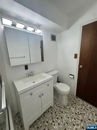 a bathroom with a sink a toilet and mirror