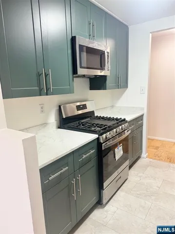 a kitchen with stainless steel appliances a stove microwave and sink