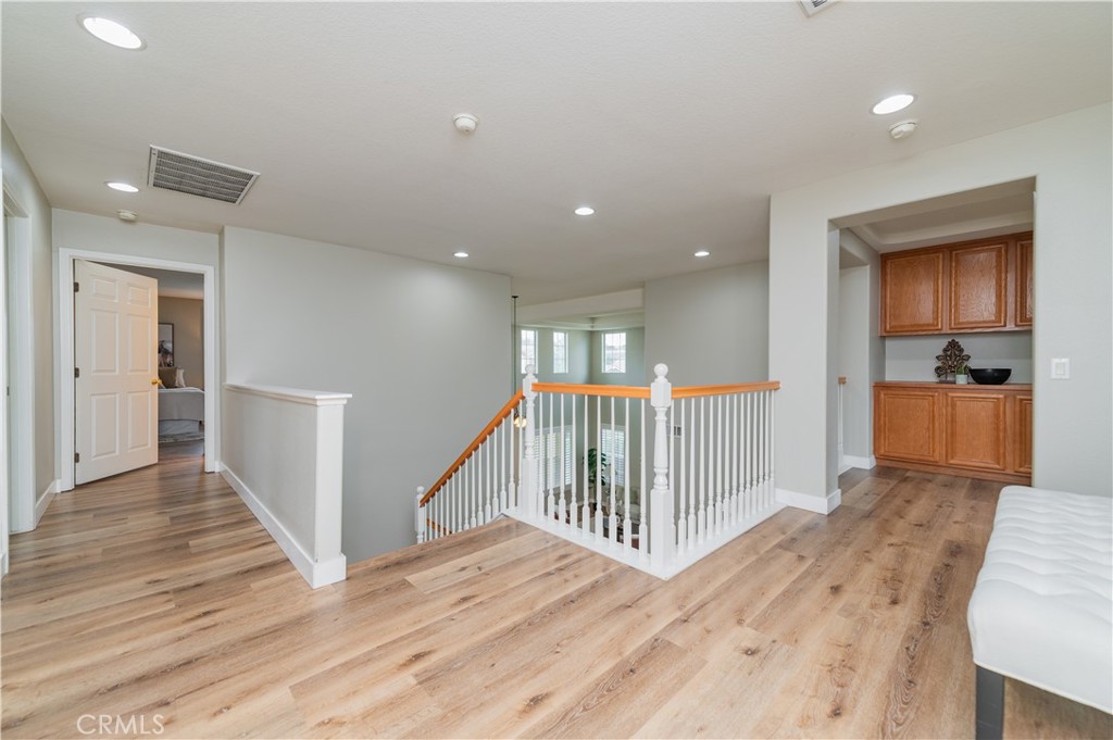 14236 Pointer Loop Eastvale, CA 92880 - Photo 19 of 38 a view of a hallway with wooden floor and entryway