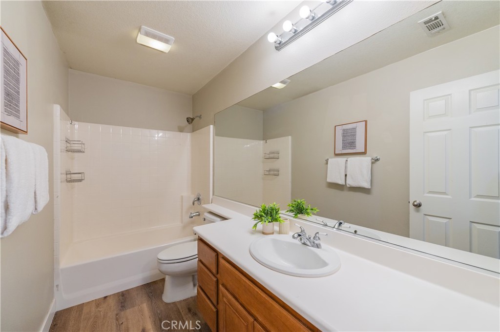 14236 Pointer Loop Eastvale, CA 92880 - Photo 22 of 38 a bathroom with a granite countertop sink a toilet and a shower