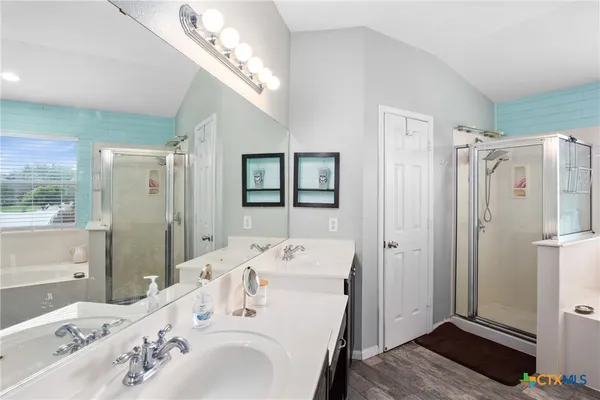 a en suite bathroom with a double vanity sink a mirror and shower
