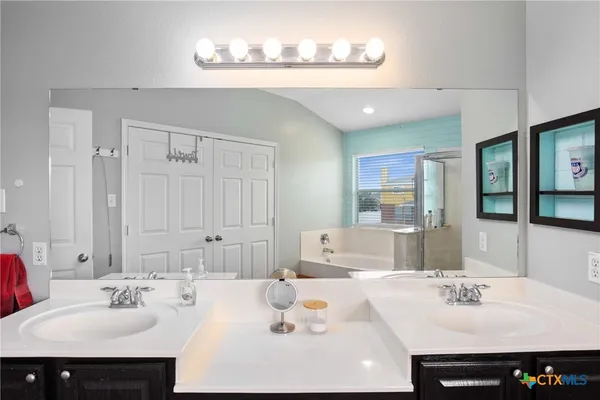 a bathroom with a sink double vanity and a mirror