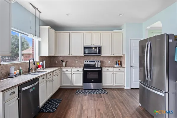 a kitchen with a refrigerator stove and sink