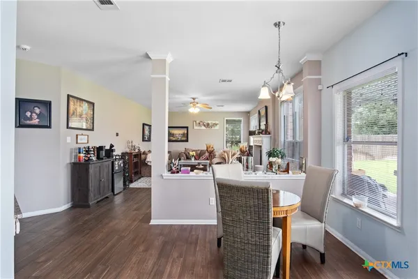 a view of a dining room and livingroom with furniture wooden floor a chandelier