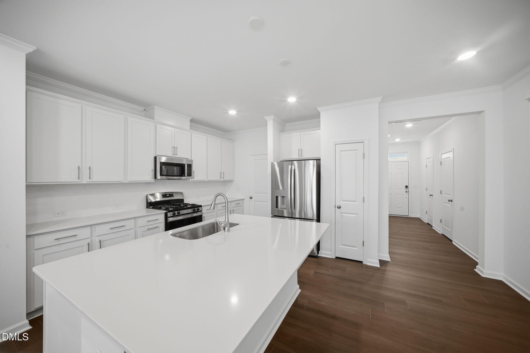 123 Tree Moss Court Rolesville, NC 27571 - Photo 11 of 33 a kitchen with stainless steel appliances a refrigerator sink and cabinets