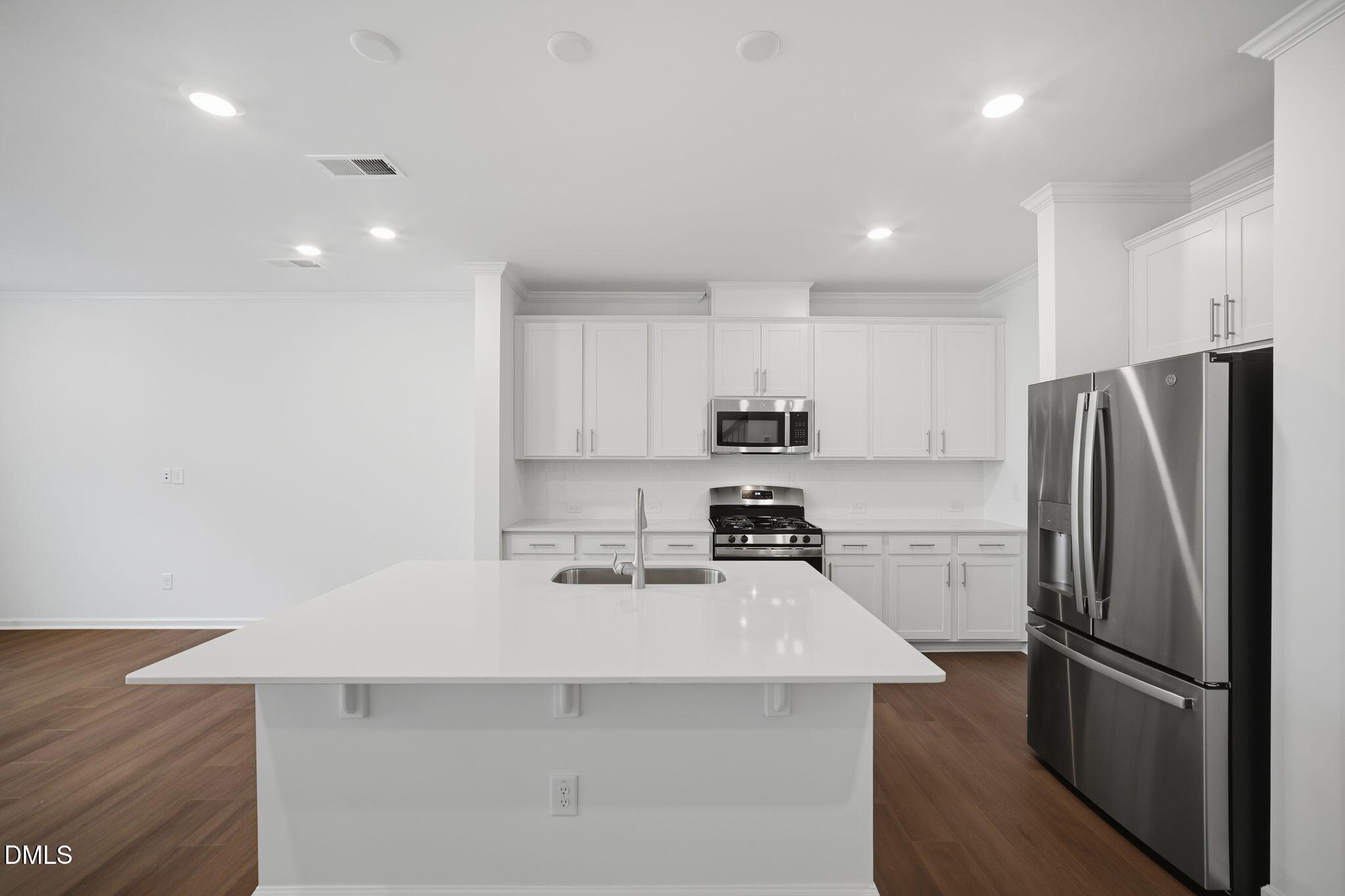 123 Tree Moss Court Rolesville, NC 27571 - Photo 12 of 33 a kitchen with stainless steel appliances a refrigerator a sink a stove a microwave and island