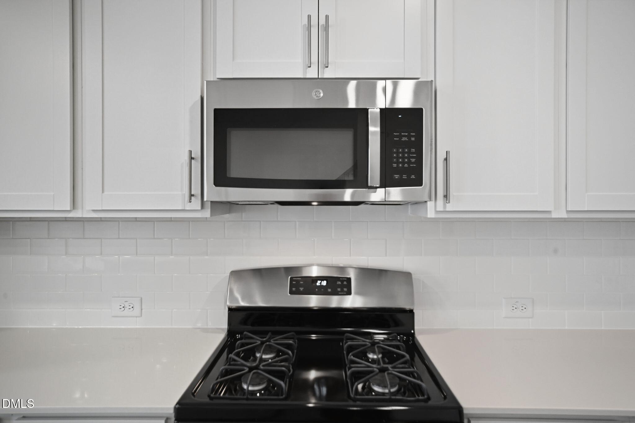 123 Tree Moss Court Rolesville, NC 27571 - Photo 14 of 33 a kitchen with a stove and a microwave