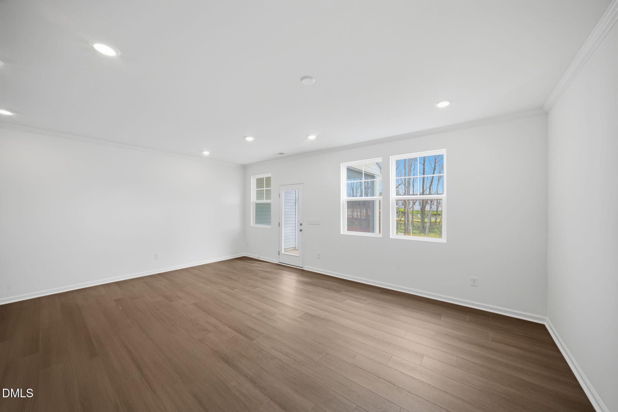 123 Tree Moss Court Rolesville, NC 27571 - Photo 16 of 33 an empty room with wooden floor and windows