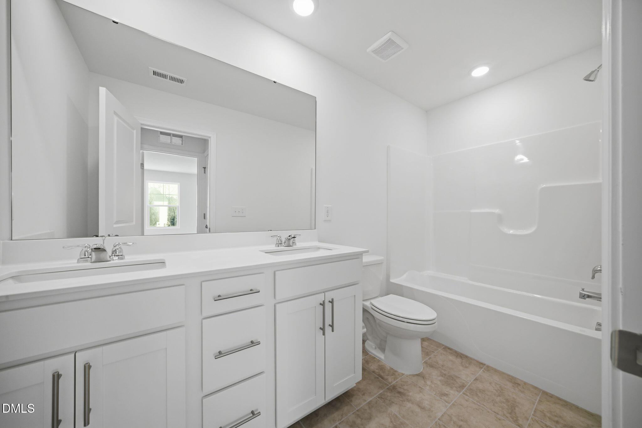 123 Tree Moss Court Rolesville, NC 27571 - Photo 17 of 33 a bathroom with a double vanity sink toilet and shower