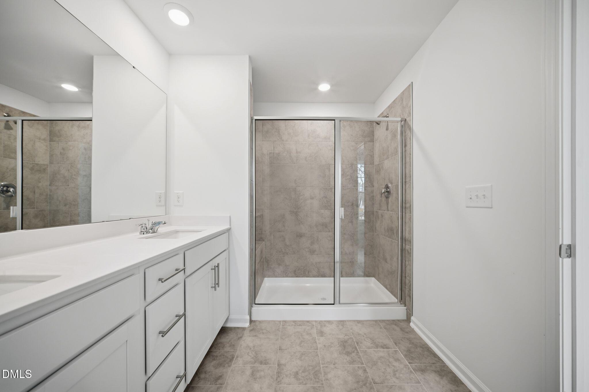 123 Tree Moss Court Rolesville, NC 27571 - Photo 27 of 33 a bathroom with a shower sink and mirror