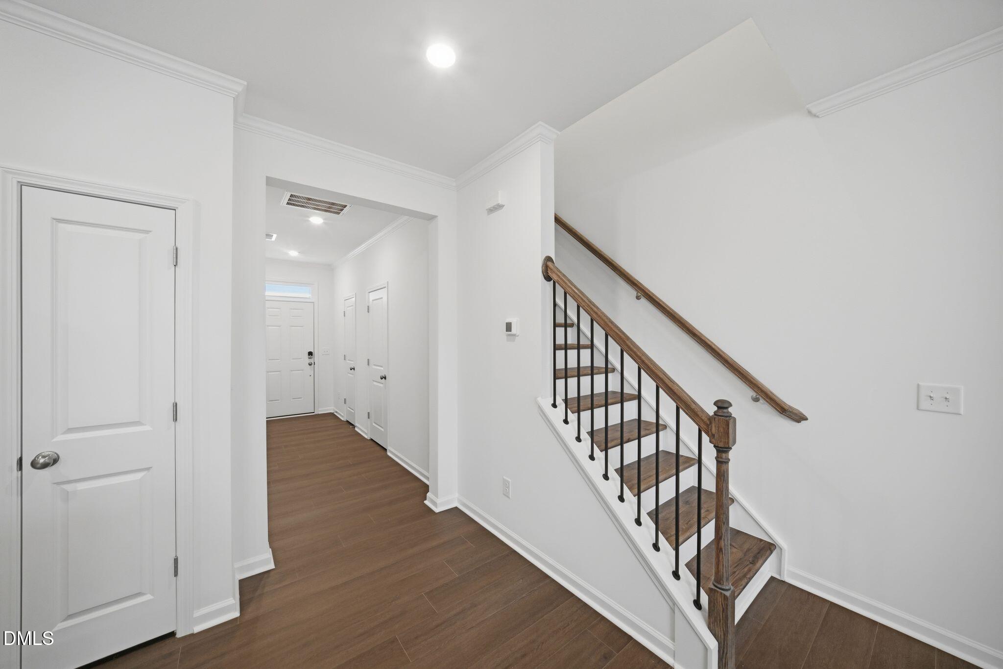 123 Tree Moss Court Rolesville, NC 27571 - Photo 4 of 33 a view of a hallway with wooden floor and staircase