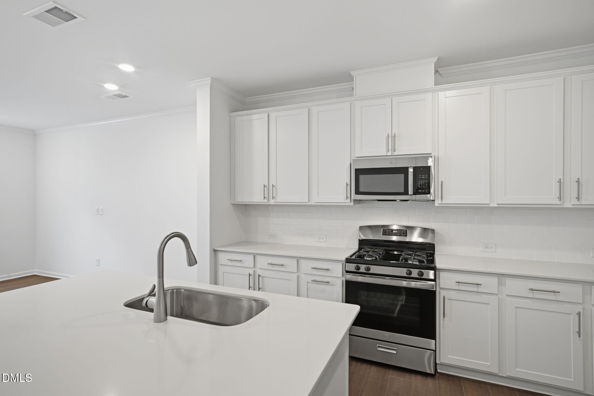 123 Tree Moss Court Rolesville, NC 27571 - Photo 9 of 33 a kitchen with granite countertop a stove and a sink