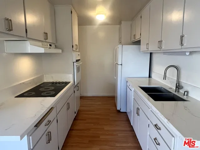 a kitchen with stainless steel appliances a sink stove and cabinets
