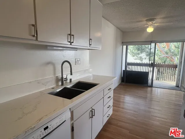 a kitchen with stainless steel appliances a sink a stove and a wooden floor
