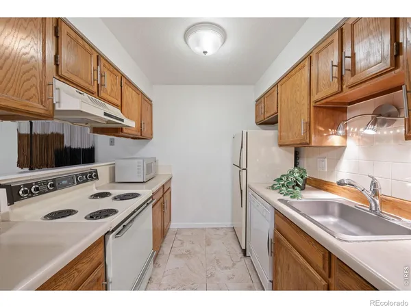 a kitchen with kitchen island granite countertop a sink a counter space and cabinets