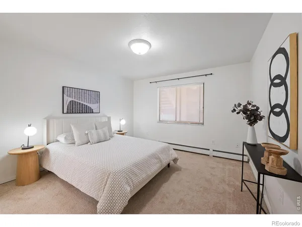 a bedroom with a bed and a painting on the wall