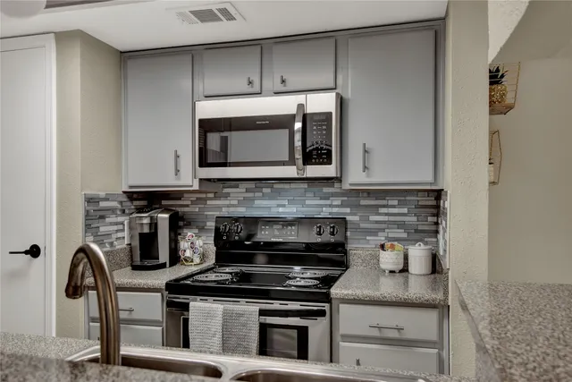 a kitchen with granite countertop a stove and a microwave