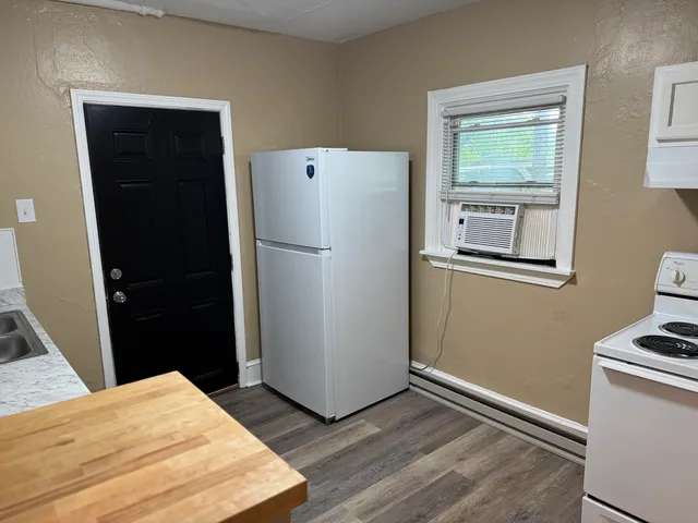 a refrigerator freezer sitting in a kitchen with wooden floor